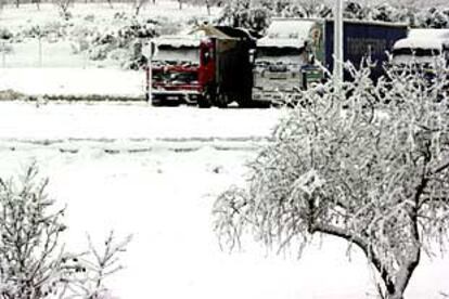 Camiones atrapados por la nieve esperan para reanudar la marcha en la provincia de Valencia.