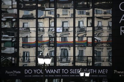 Una bandera reflejada en las ventanas de un hotel de la plaza de Pedro Zerolo.