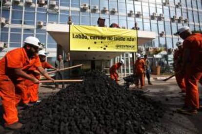 Activistas del grupo ecologista Greenpeace protestan colocando carbn en frente del Ministerio Minas y Energia en Brasilia.