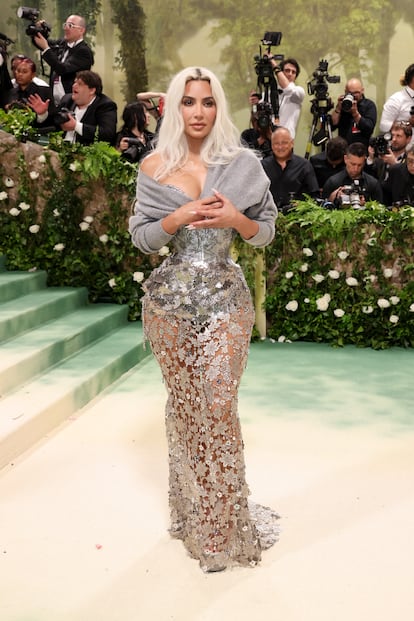 Kim Kardashian se ha decantado por uno de los diseñadores triunfadores de la noche, John Galliano. Lleva un vestido transparente con brocados metalizados y una chaqueta de punto de Maison Margiela.