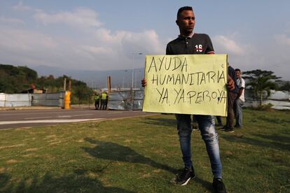 Un hombre sostiene un cartel en el que pide la llegada inmediata de ayuda humanitaria en el puente de Tienditas, bloqueado este miércoles por el Ejército venezolano. Las obras de este puente fueron concluidas a mediados de 2016. En esa fecha Maduro ya había ordenado el cierre de la frontera y el puente nunca se ha llegado a inaugurar. Desde entonces ha permanecido sellado, aunque en perfectas condiciones.