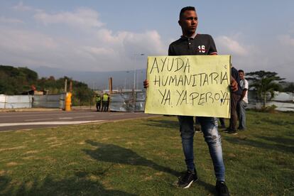 Un hombre sostiene un cartel en el que pide la llegada inmediata de ayuda humanitaria en el puente de Tienditas, bloqueado este miércoles por el Ejército venezolano. Las obras de este puente fueron concluidas a mediados de 2016. En esa fecha Maduro ya había ordenado el cierre de la frontera y el puente nunca se ha llegado a inaugurar. Desde entonces ha permanecido sellado, aunque en perfectas condiciones.