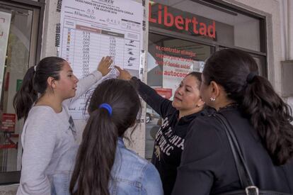 Un grupo de mujeres observa los resultados de votos en una casilla en Atlacomulco.