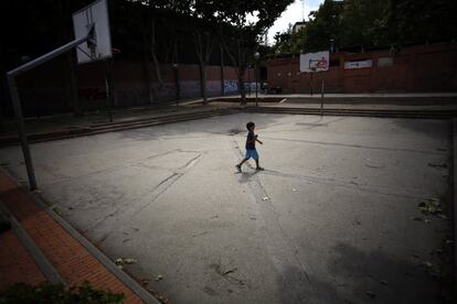 Un niño camina el martes por la pista de baloncesto de la plaza de los Poetas, en Valdezarza. Los vecinos se quejan de que esta zona, como otras del barrio, están descuidadas y la suciedad se acumula sobre el pavimento.