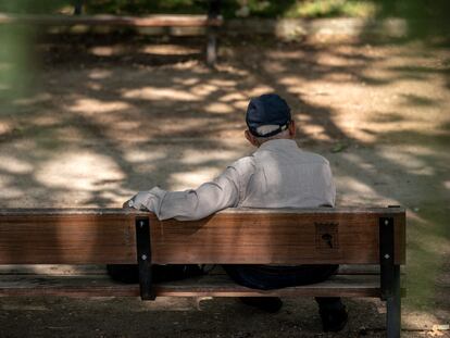 Un hombre mayor sentado solo en un banco del parque Caramuel, en el barrio de Puerta del Ángel, Madrid.
