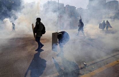 Anti-government protesters shielded themselves from tear gas canisters at a street protest in Caracas on Thursday.