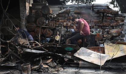 El empleado de una tienda india se lamenta sentado junto a su mercancía calcinada tras el incendio declarado en el mercado mayorista de Kamla, en Nueva Delhi (India).