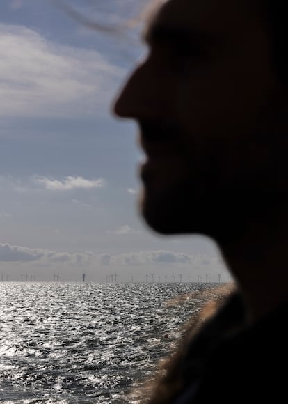 Armstrong McKay, en Brighton. Al fondo, un parque eólico marino visto desde la costa. 