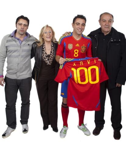 Xavi posa junto a sus padres y su hermano con una camiseta que en el dorsal luce el número 100, los partidos que podría cumplir mañana con España.