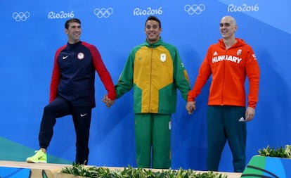 Michael Phelps (i), Chad le Clos (c) y Laszlo Cseh, medallistas de plata en 100m mariposa.