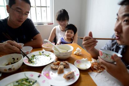 De izquierda a derecha, el padre, la madre con Jiang, y un amigo de la familia almuerzan juntos el domingo en el comedor del piso. Es uno de los pocos momentos en los que están todos juntos.