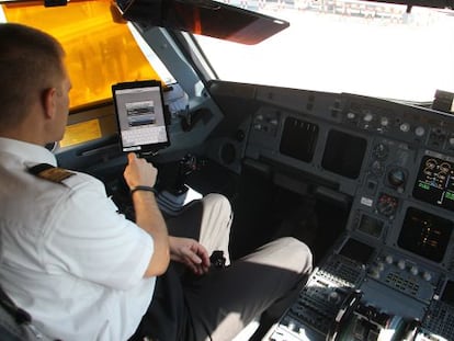 Un piloto de Iberia revisa el libro de ruta en la cabina del avi&oacute;n. / Pablo Monge