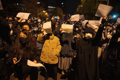 Manifestantes sostienen papeles en blanco y corean consignas en una protesta en Pekín contra las medidas anticovid, el 27 de noviembre de 2022.