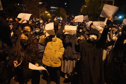 Manifestantes sostienen papeles en blanco y corean consignas en una protesta en Pekín contra las medidas anticovid, el 27 de noviembre de 2022.