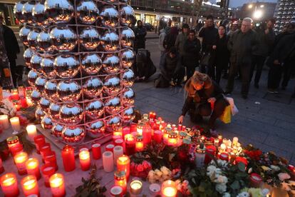 En el atentado perpetrado el lunes en Berlín han muerto 12 personas, 48 están heridas y 18 se encuentran en estado muy grave. En la imagen, una mujer enciende una vela en la entrada al mercado de Navidad en el que un camión arrolló a la multitud en Berlín.