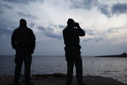 Dos agentes de la Guardia de Finanzas italiana controlan el tránsito de barcos desde Lampedusa.