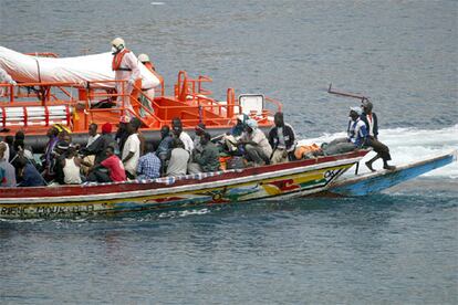 Un cayuco con 67 inmigrantes a bordo, junto a una embarcación de Salvamento Marítimo, llega ayer al puerto tinerfeño de Los Cristianos.