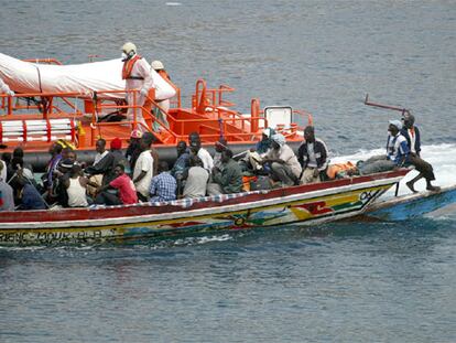 Un cayuco con 67 inmigrantes a bordo, junto a una embarcación de Salvamento Marítimo, llega ayer al puerto tinerfeño de Los Cristianos.