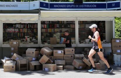 Un corredor pasa delante de unas casetas de la Feria del Libro un día antes de su inauguración.