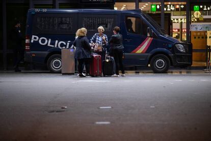 Unas viajeras junto a un vehículo de la Policía Nacional, en la estación de Sants, este viernes.