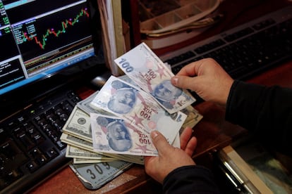 Un cambista cuenta billetes en una oficina de cambio en Ankara. El billete de 100 liras ha pasado de valer 11 euros a inicios de año a 8 euros en la actualidad.