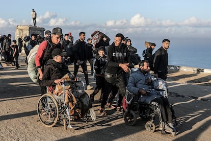 Gazatíes desplazados llevan a sus familiares heridos por la carretera de Salahadín, de vuelta a sus hogares al norte de la Franja, este lunes.