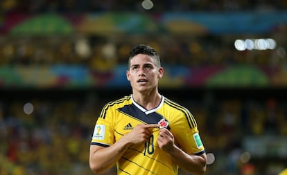 James Rodíguez se señala el escudo de la selección de Colombia tras marcar un gol a Japón en la fase de grupo del Mundial de Brasil.