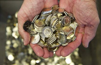 Un hombre sostiene varias monedas de euro en una imagen de archivo.