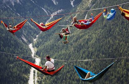 Atletas aficionados al deporte Extremo descansan colgados sobre unas hamacas durante el encuentro internacional "Highline" en Monte Piana, Cerca de Misurina, en los Alpes Italianos.