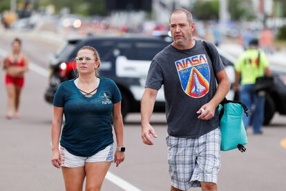 Dos personas, ambas con camisetas de la NASA, asisten este sábado al despegue de la de la nave 'Crew Dragon' desde Cabo Cañaveral.