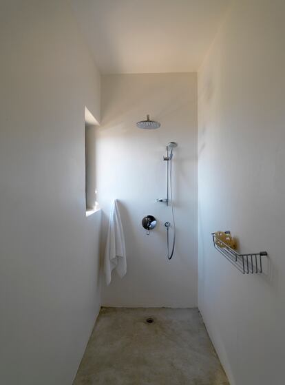 Los baños son sencillos y están pintados de blanco. Los grifos y la ducha son de Hansgrohe, y los toalleros, portarrollos y demás accesorios del baño, de Cosmic Studio.