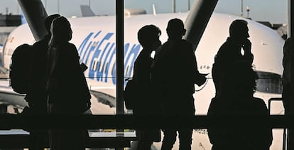 Viajeros en la T4 de Madrid-Barajas con un avión de Air Europa de fondo.