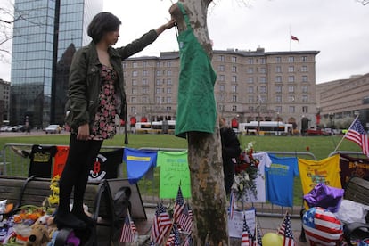 Una empleada de Starbucks, uno de los establecimientos afectados por la explosión en Boylston Street, coloca un delantal en un homenaje a las víctimas.