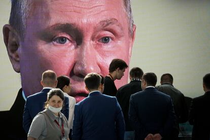 Participants watch Russian President Vladimir Putin's addressing a plenary session of the St. Petersburg International Economic Forum