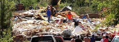 Una familia busca entre los restos de su vivienda arrasada por un tornado en el condado de Washington, en Alabama.