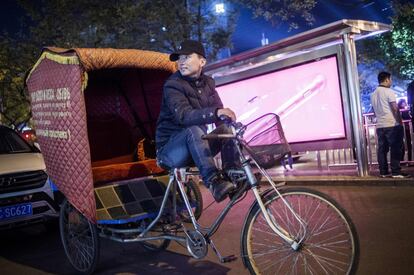 El conductor de bicitaxi Li Wei espera clientes en las calles de Pekín.