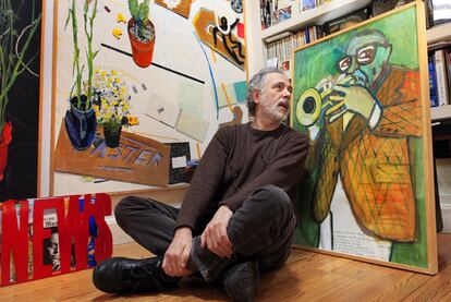 Fernando Trueba en su estudio, <i>escuchando </i>un cuadro de Javier Mariscal.