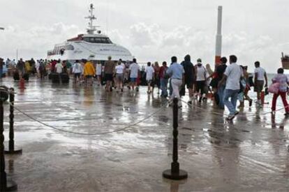 Decenas de turistas salen del muelle de Playa del Carmen al caer las primeras lluvias que preceden la llegada del Wilma.