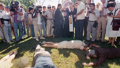 El arzobispo de El Salvador, rodeado de periodistas, junto a los cadáveres de las víctimas, en 1989.