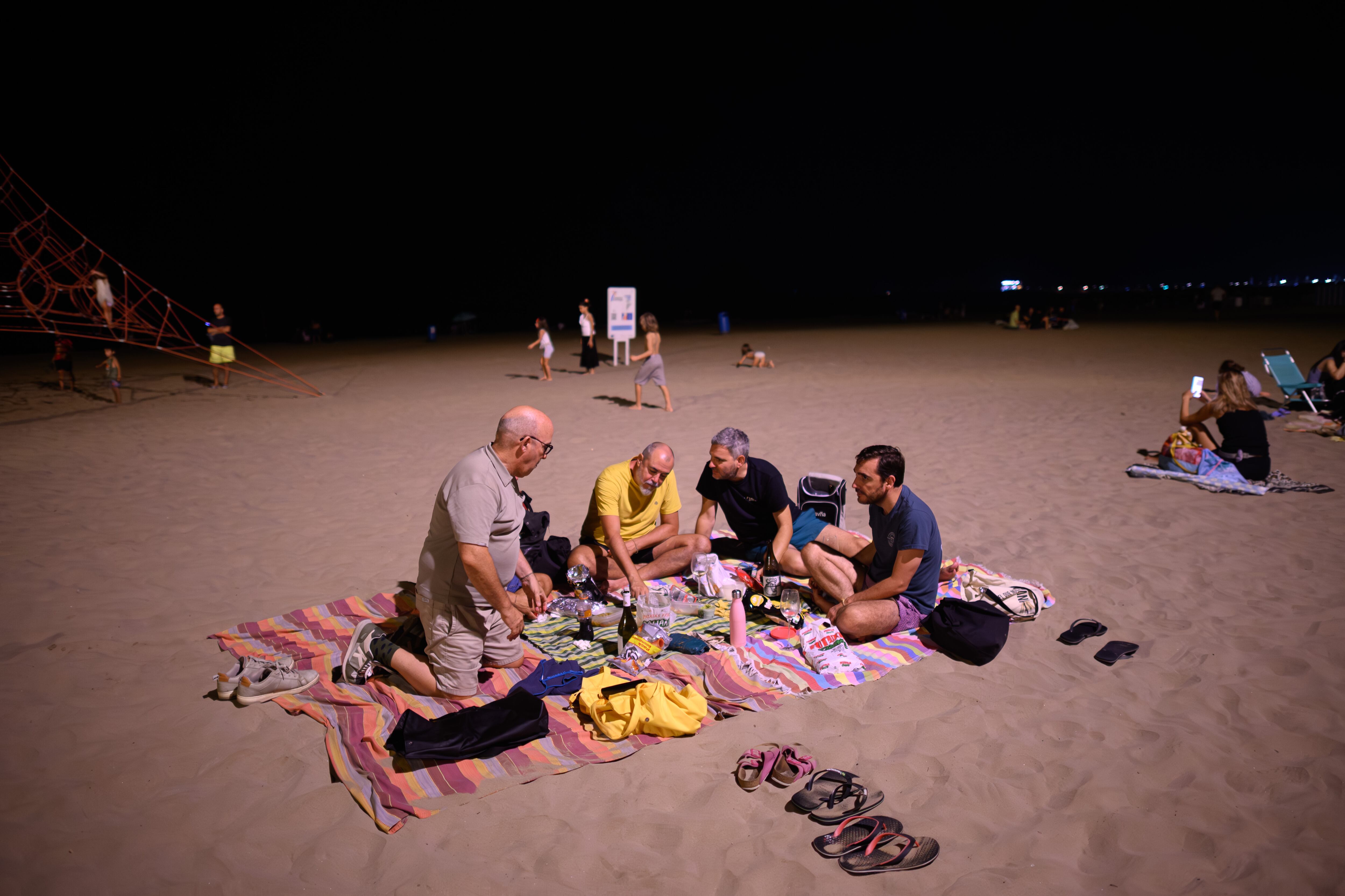 Vecinos de Valencia cenan en la playa durante la reivindicación vecinal en defensa de esta tradición popular.