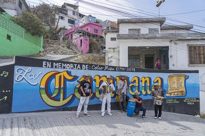 Músicos posan para una fotografía frente a un mural a las afueras de la casa del fallecido cantante Celso Piña, en el cerro de la Campana.