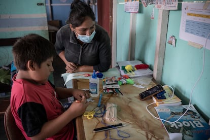 Jairo Chuquimán asiste a una clase  virtual a través del móvil el 12 de marzo de 2021 en presencia de su madre, Zaida Luján, en su casa del barrio 30 de Octubre de Perú, Lima. Pincha en la imagen para ver la fotogalería completa.