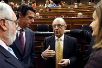 El ministro de Hacienda y Administraciones Públicas, Cristóbal Montoro (2d), conversa con los ministros, de Agricultura, Alimentación y Medio Ambiente, Miguel Arias Cañete (i); de Industria, Energía y Turismo, José Manuel Soria (2i), y de Empleo, Fátima Báñez (d), al inicio del pleno, esta mañana en el Congreso de los Diputados.