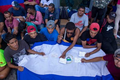 Migrantes centroamericanos muestran el documento que les otorgó el INM, mismo que les permite el libre tránsito por el territorio mexicano.