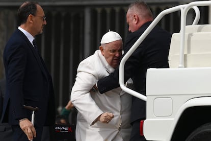 El papa Francisco es ayudado a sentarse en una silla de ruedas durante la audiencia de este miércoles en el Vaticano.