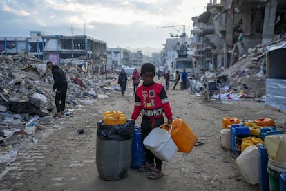 Un niño palestino cargaba ayer con bidones entre la desvastación de Yabalia, en el norte de Gaza. 