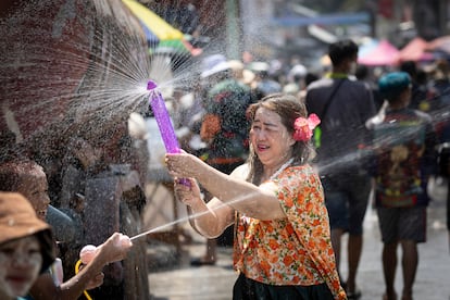 Es típico vestirse con camisas de flores y con ropas de una gran variedad de colores. Además de la batalla de agua, para muchos esta fiesta también es el momento de reunirse con la familia y visitar templos. En la foto, una mujer utiliza un aparato para salpicar agua a su alrededor.