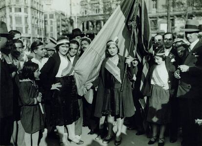 Dones amb cintes tricolors i la bandera republicana a la plaça de Catalunya de Barcelona el 15 d'abril de 1931.
 