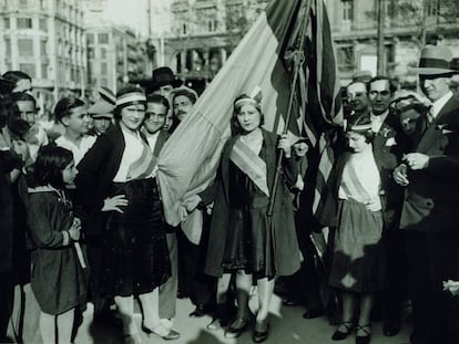 Dones amb cintes tricolors i la bandera republicana a la plaça de Catalunya de Barcelona el 15 d'abril de 1931.
 