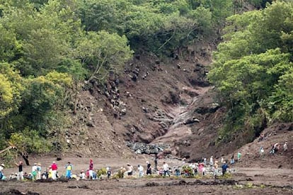 Decenas de voluntarios procedentes de las aldeas vecinas buscan cuerpos debajo del barro en la localidad guatemalteca de Panabaj tras un alud de lodo.